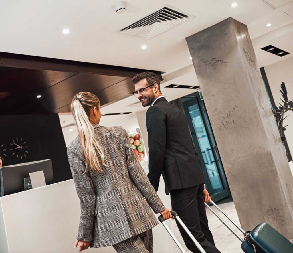 Man och kvinna i en lobby med vars en resväska