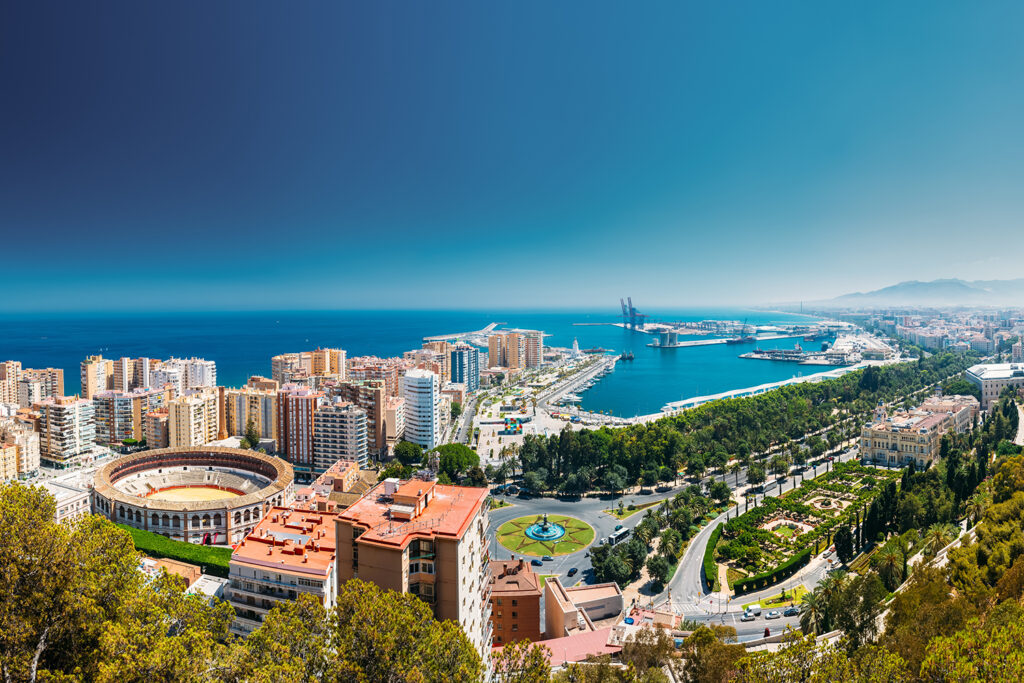 Panoramavy över Malaga med hamn, kust och stad – solsäkert resmål för kickoff, konferensresa och gruppresa året runt.