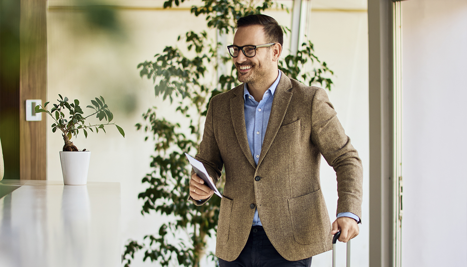 Deltagare med resväska anländer till hotellet.
